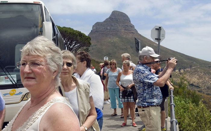 FILE: A group of tourists get off their tour bus at the bottom of the cable station to Table Mountain in Cape Town. Picture: AFP