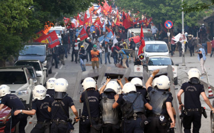 Protesters face Turkish riot police using tear gas in Ankara on 14 May, 2014, during a demonstration gathering hundreds after more than 200 people were killed in an explosion at a mine. Picture: AFP. 