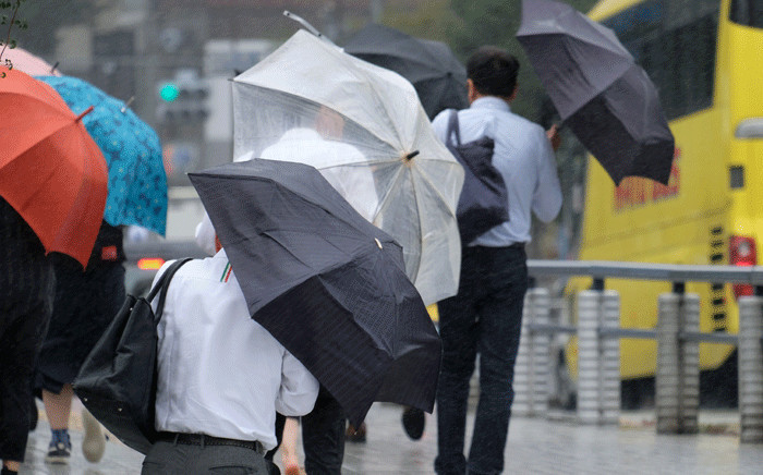 FILE: Pedestrians holding umbrellas walk in the rain in Tokyo on 8 August 2018. A powerful typhoon was churning towards Japan on August 8, prompting the weather agency to warn of heavy rain and strong winds and forcing airlines to cancel scores of flights. Picture: AFP