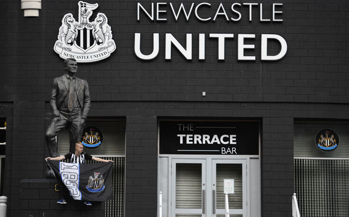 A Newcastle United supporter is seen posing in front of the statue of the late former manager Bobby Robson outside the club's stadium St James' Park in Newcastle upon Tyne in northeast England on 8 October 2021, after the sale of the football club to a Saudi-led consortium was confirmed the previous day. Picture: Oli Scarff/AFP