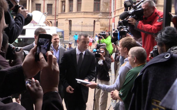 Oscar Pistorius receives a bible from a supporter as he enters the High Court in Pretoria ahead of his murder trial on 17 April 2014. Picture: Christa van der Walt/EWN