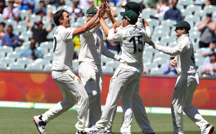Australia's Pat Cummins (L) celebrates with teammates after dismissing India's captain Virat Kohli as India is all out for only 36 runs on the third day of the first cricket Test match between Australia and India played in Adelaide on 19 December 2020. Picture: AFP