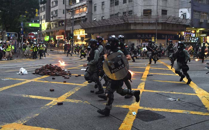 Hong Kong police advance down a road during clashes with protesters in the Wanchai district in Hong Kong on 6 October 2019. A Hong Kong judge on October 6 rejected a challenge to an emergency law criminalising protesters wearing face masks as democracy activists hit the streets again in defiance of the ban despite half the city's subway stations remaining closed. Picture: AFP

