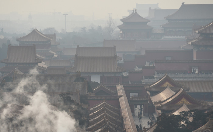 Steam rises behind a wall of the Forbidden City, once the home of Chinas emperors, on a polluted day in Beijing on 19 December 2015. The Chinese capital issued its second-ever red alert for pollution and put its emergency response plan into action, ordering factories to close and pulling half of all private cars off the streets. Picture: AFP.