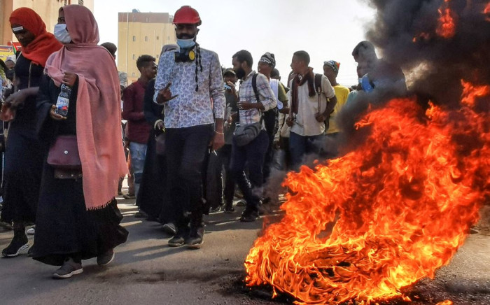 Sudanese protesters rallying against the military, walk past burning tyres in the capital Khartoum, on January 6, 2022. Picture: AFP 