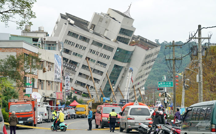 Rescue and emergency workers block off a street where a building came off its foundation, the morning after a 6.4 magnitude quake hit the eastern Taiwanese city of Hualien, on 7 February 2018. Picture: AFP
