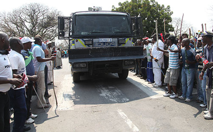 Anglo Platinum miners make way for a police vehicle, as they march, demanding better wages. Picture: Taurai Maduna/EWN.