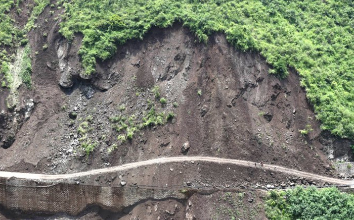 FILE: A landslide aftermath is pictured along a damaged road. Picture: AFP.