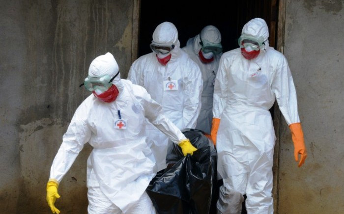 FILE: Medical workers of the Liberian Red Cross, wearing a protective suit, carry the body of a victim of the Ebola virus in a bag on 4 September, 2014 in the small city of Banjol, 30 kilometres of Monrovia. Picture: AFP.