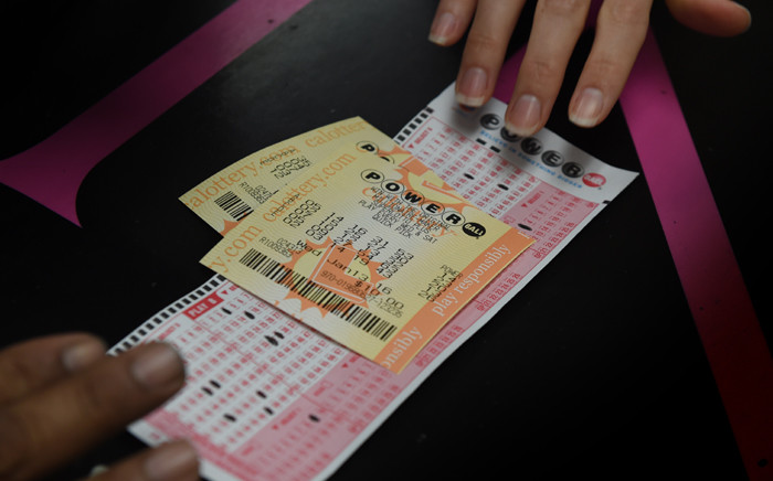 FILE: A customer picks up her California Powerball lottery tickets at the famous Bluebird Liquor store which is considered to be a lucky retailer of tickets, in Hawthorne, California on 13 January, 2016. Picture: AFP.
