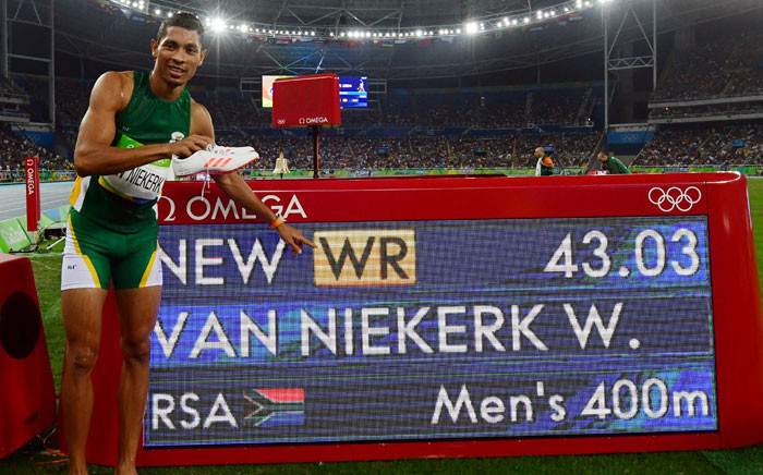 South Africa's 400m Olympic gold medallist Wayde van Niekerk points to his new world record displayed on a board after the Men's 400m Final at the Rio 2016 Olympic Games at the Olympic Stadium in Rio de Janeiro on August 14, 2016. Picture: AFP.