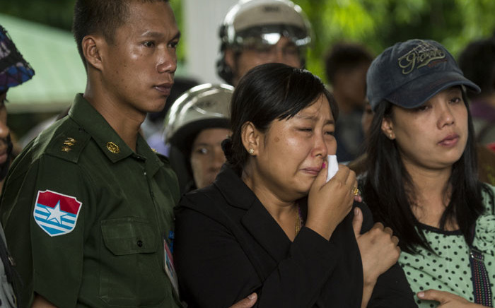 Khine Zin Win (C), who lost her youngest brother and his family, cries during the funeral in Dawei on June 9, 2017. Heavy rains and churning seas hampered search efforts for victims of a military plane crash off Myanmar's southern coast. Picture: AFP