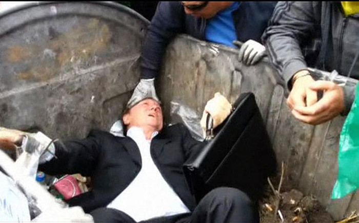 A screengrab of Vitaly Zhuravsky being thrown into a trash bin by angry protesters in Ukraine on 16 September, 2014.