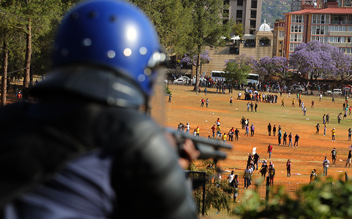 FILE: A police officer gets ready to fire rubber bullets as the crowd of students disperse during protests over proposed university fee increases at the Union Buildings in Pretoria on 23 October 2015. Picture: Reinart Toerien/EWN