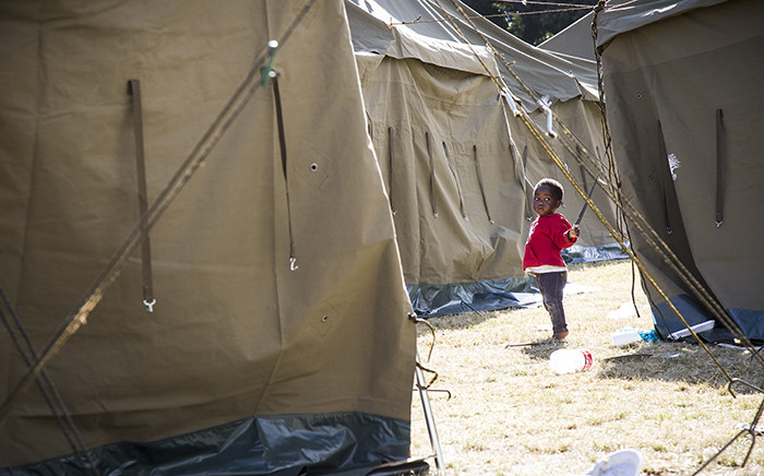 A little girl plays with a guy rope on one of the tents in the displaced foreign nationals camp in Primrose. Picture: Thomas Holder/EWN