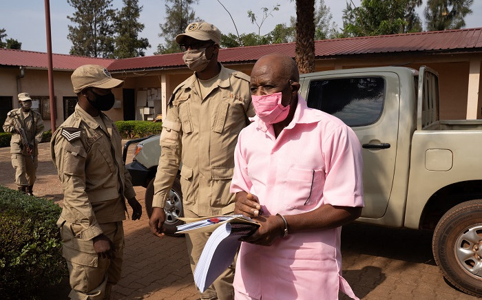 FILE: In this file photo taken on 25 September 2020 'Hotel Rwanda' hero Paul Rusesabagina (R) in the pink inmate's uniform arrives from the Nyarugenge prison with Rwanda Correctional Service officers at the Nyarugenge Court of Justice in Kigali, Rwanda. Picture: Simon Wohlfahrt /AFP.