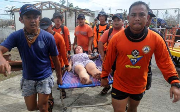 Rescue workers carry a woman about to give birth at a makeshift Department of Health medical center at the Tacloban airport in the aftermath of Super Typhoon Haiyan in Tacloban, eastern island of Leyte on November 9, 2013. Picture: AFP.