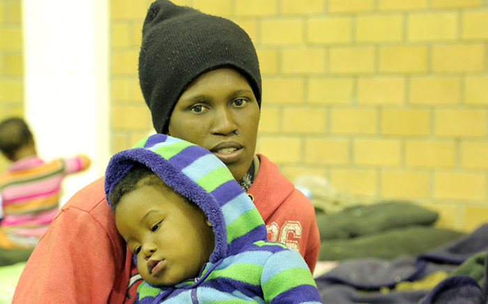 A woman and her baby sit on a matress in the Nomzamo Community Centre on 4 June,2014 following their forced eviction. Picture: Aletta Gardner/EWN.