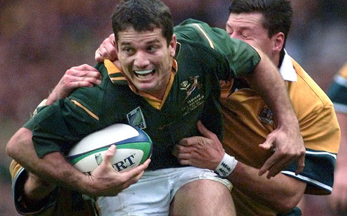 Joost Van Der Westhuizen (front) is tackled by Australian fullback Matthew Burke (R) during the Rugby World Cup semi-final match between Australia and South Africa at Twickenham stadium 30 October 1999. Picture: AFP.