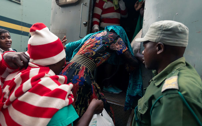 In this file photo taken on 16 December 2019, Marry Mubaiwa, the wife of Zimbabwe vice-president Constantino Chiwenga, covers her head with a wrap as she climbs into the back of a prison vehicle, in order to leave the Harare Magistrates Court. Picture: AFP