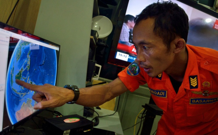 FILE: An official from Indonesia’s national search and rescue agency in Medan, North Sumatra points at his computer screen to the position where AirAsia flight QZ8501 went missing off the waters of Indonesia on December 28, 2014. Picture: AFP.