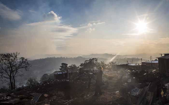 As the sun rises, a spotter plain searches for fire hot spots in Knysna. Picture: Thomas Holder/EWN.