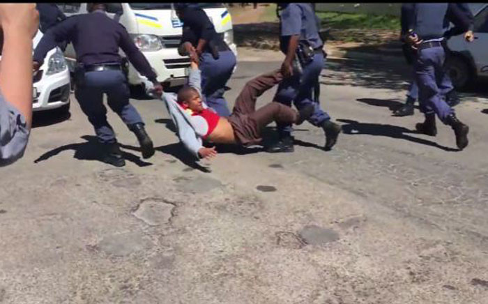 A man is dragged into a police van after officers fired rubber bullets at protesting students at Rhodes University on 28 September 2016. Picture: Screenbgrab