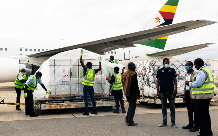 Workers offload part of a consignment of the Sinopharm coronavirus vaccine from China off an Air Zimbabwe plane. Picture: AFP