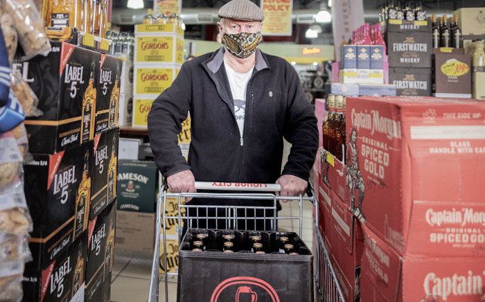 A customer buys alcohol at a liquor shop in Melville, Johannesburg, on 18 August 2020. South Africa moved into level two of a five-tier lockdown on 18 August 2020, to continue efforts to curb the spread of the COVID-19 coronavirus. Under level two, liquor and tobacco sales will resume. Picture: AFP