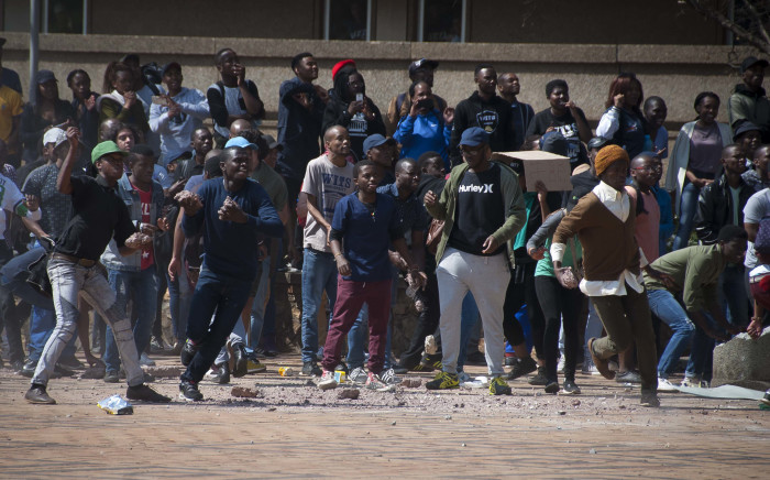 FILE: Students hurl rocks at private security at Senate House at Wits University during fees must fall protests. Picture: Nina Leslie/i-Witness.
