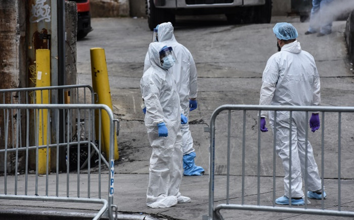 FILE: Medical workers remove a body from a refrigerated truck outside of the Brooklyn Hospital on 31 March 2020 in New York City. Due to a surge in deaths caused by the coronavirus, hospitals are using refrigerated trucks to makeshift morgues. Picture: AFP.
