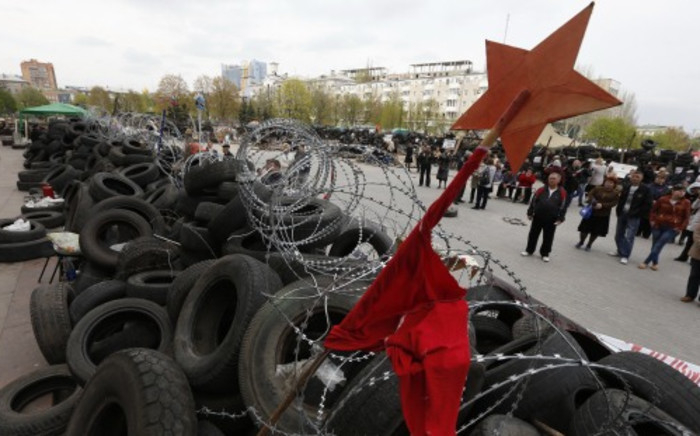 Pro-Russian protesters stand in front of a barricade in front of an occupied building of the Regional State Administration in Donetsk on 20 April. Picture: AFP.