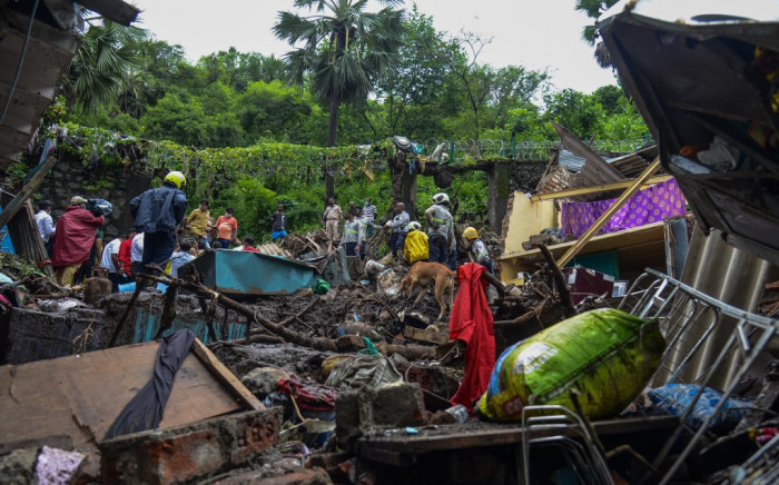 National Disaster Response Force (NDRF) and other rescue team personnel inspect the site of the landslide in a slum area where 23 people were killed after several homes were crushed by a collapsed wall and a landslide triggered by heavy monsoon rains in Mumbai on 18 July 2021. Picture: Sujit Jaiswal / AFP