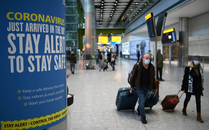 Coronavirus health warnings are seen in the arrivals hall at London Heathrow Airport in west London, on 15 January 2021. Picture: DANIEL LEAL-OLIVAS/AFP