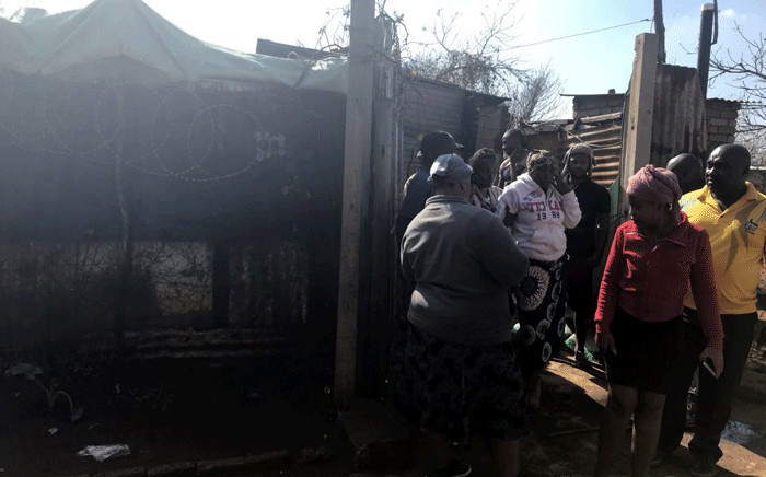 Bekkersdal community members congregate at the shack where three children were killed during a fire on 29 May 2018. Picture: Thando Kubheka/EWN
