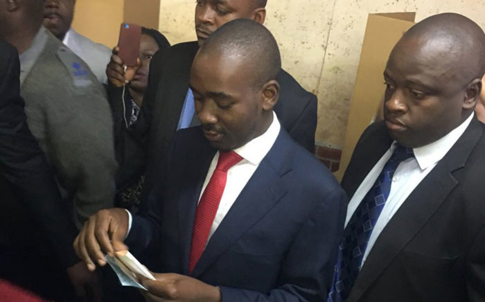 MDC Alliance leader Nelson Chamisa (wearing red tie) prepares to cast his vote in Zimbabwe's presidential elections on 30 July 2018. Picture: EWN
