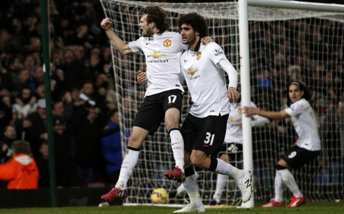 FILE: Manchester United’s Dutch midfielder Daley Blind (L) celebrates scoring his goal with Manchester United’s Belgian midfielder Marouane Fellaini. Picture: AFP. 