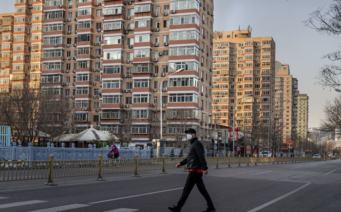 FILE: A man wearing a protective mask walks along an empty street in Beijing on 31 January 2020, following a SARS-like virus outbreak which began in the Chinese city of Wuhan. Picture: AFP