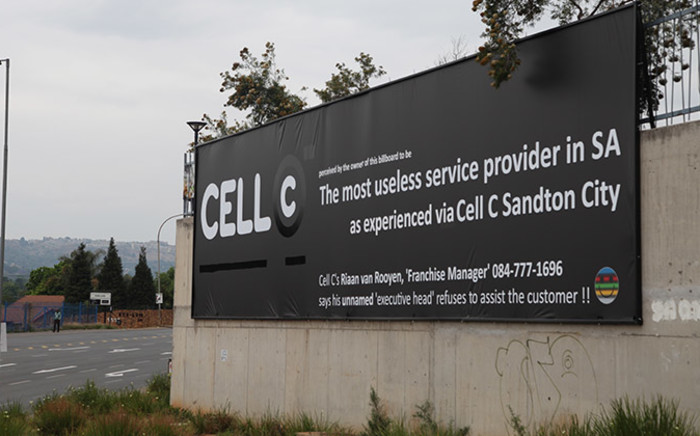 The banner erected by a disgruntled Cell-C customer outside the World Wear shopping centre on Beyers Naude drive in Fairland, Johannesburg was altered after the cellphone company sought legal advice on the matter. Picture: Reinart Toerien/EWN