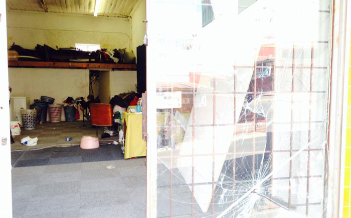 A Ugandan national runs this Laundromat in Jeppestown. Her glass door was damaged with rocks as locals attempted to gain entry but couldn't because police rapidly responded to the incident. Picture: Masego Rahlaga/EWN.