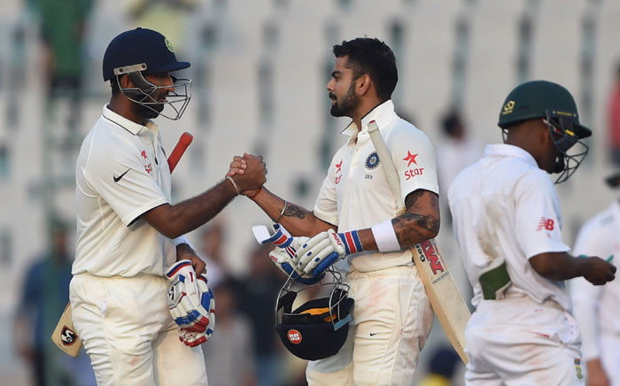 India's Cheteshwar Pujara (L) and captain Virat Kohli gesture during play on the second day of the first Test cricket match between India and South Africa at The Punjab Cricket Association Stadium in Mohali on 6 November, 2015. Picture: AFP.