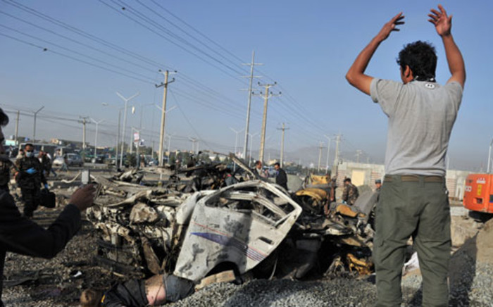 A man looks at the carnage, outside a petrol station at the site of a suicide attack in Kabul on September 18, 2012. A suicide bomber blew himself up alongside a minivan carrying foreigners on a major highway leading to the international airport in the Afghan capital, police said, killing at least 10 people, including nine foreigners. Picture: AFP.