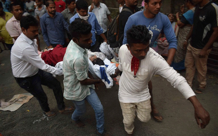 Indian local residents and rescue workers carry a survivor after a fire incident at the ESIC Kamgar hospital in Mumbai on December 17, 2018. Six people were dead after a fire broke out in a five-storey hospital, local media reported. Picture: AFP.