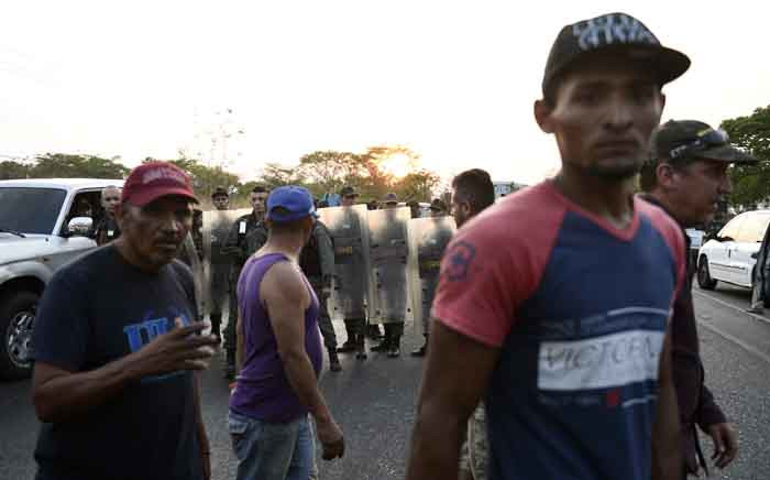 Local residents get angry as the National Guard blocks the main highway to keep out convoys heading to the border with Colombia to try to collect the humanitarian aid that the government of President Nicolas Maduro is not allowing into the country, in San Carlos, Cojedes state, Venezuela on 21 February 2019. Picture: AFP
