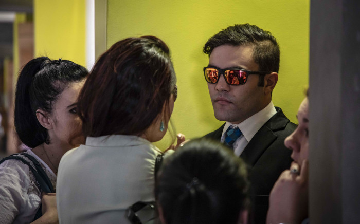 Collan Rex (wearing sunglasses), who has been convicted of 144 counts of sexual assault and 12 counts of common assault, waits outside the courtroom for sentencing at the Palmridge Magistrates Court. Picture: Thomas Holder/EWN