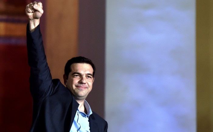 FILE: Syriza leader Alexis Tsipras raises his fist as he greets supporters following victory in the election in Athens. Picture: AFP