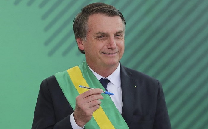 Brazil' President Jair Bolsonaro poses with the pen used during the swearing-in ceremony for the ministers at the Planalto Palace in Brasilia on 1 January 2019, after his own inauguration at the national Congress. Picture: AFP.