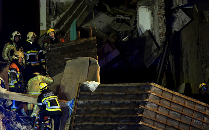 Firefighters inspect a collapsed building, at the Paardenmarkt in Antwerp on 15 January, 2018, after several buildings collapsed following an explosion. Picture: AFP.