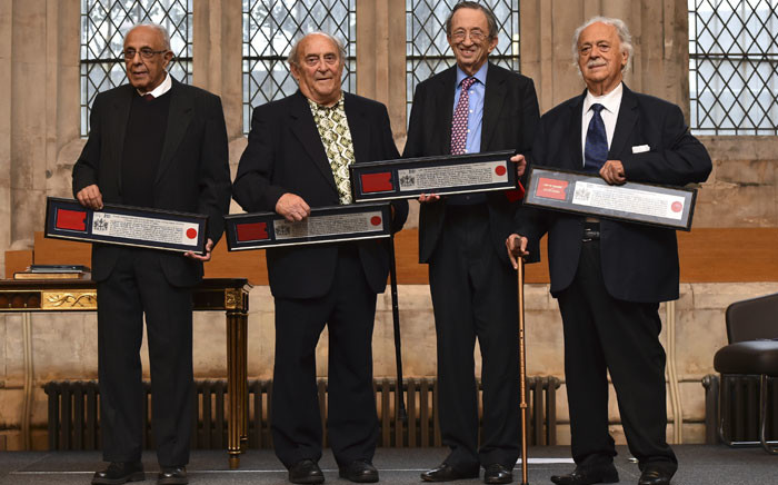 (L-R) South African politician Ahmed Kathrada and South Afrian social campaigner Denis Goldberg, both who were active in the anti-apartheid struggle and formerly imprisoned with Nelson Mandela at Robben Island, along with members of their legal defence team South African-born British lawyer Joel Joffe and Greek lawyer George Bizos, pose holding certificates of their award of the Freedom of the City of London during a ceremony at the Guildhall in London on January 27, 2016. The four along with a third former prisoner Andrew Mlangeni, who was unable to attend, received their awards in reognition of their fight for freedom and recial equality. Picture:  AFP.