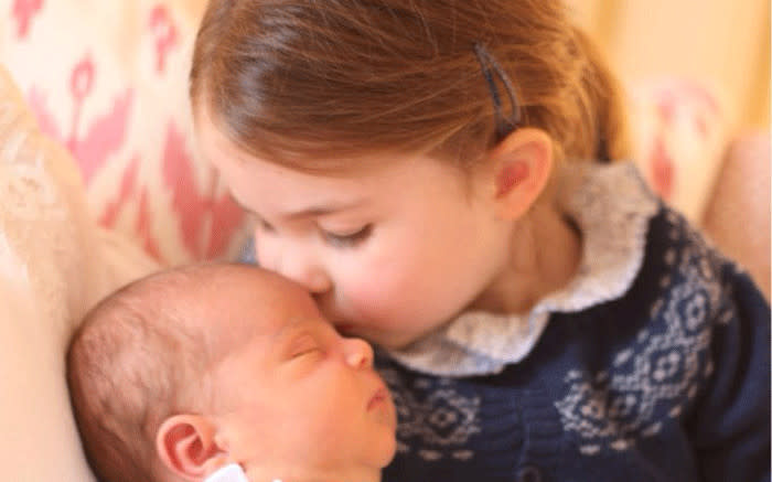 Princess Charlotte plants a kiss on her new baby brother Prince Louis' forehead. Picture: The Duchess at Kensington Palace/@KensingtonRoyal